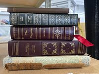 Stack of six classic hardcover books showing spine titles of Darwin, Copperfield, Virginian, Omar Khayyam, and others