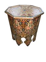 Front angle of the octagonal wooden stand showing the floral painted designs on the sides and part of the top patterns.