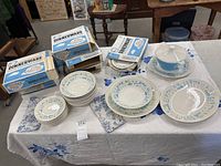 Display of dinnerware pieces with original boxes
