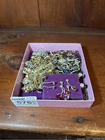 Full box of assorted rhinestone costume jewelry including necklaces, bracelets, and earrings.