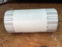 Wrapped paper roll with gray stripes on wooden surface