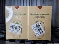 Photo of two boxed rechargeable hand warmers with labels and packaging text visible