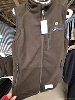 Front view of black fleece electric heated vest for women, size medium, showing full front zipper, embroidered Ororo logo on chest pocket, and zippered side pockets.
