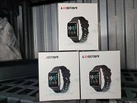 Three boxes of L8star black silicone band smart watches stacked on a shelf. Each box shows the watch with digital display and black silicone strap.