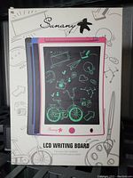 Front box showing three color variants of the Sunany LCD Writing Board and illustration of its usage with doodles.