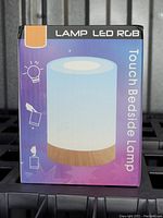 Front of the product box showing the LED RGB touch bedside lamp with a faux wood base and the product name and illustration.
