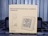 Front of the beige box showing a digital hygrometer thermometer with wireless sensor and digital screen displaying temperature and humidity.
