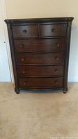 Front view of dresser showing all six drawers and decorative accents