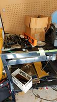 Additional hand tools and clamps on shelf with level and boxed Black & Decker tools