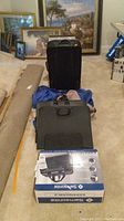 Overall view of lot items including a black hard case suitcase, blue and black rolling duffel, black portfolio and Samsonite portfolio box.