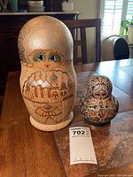 Photo of largest and second largest Babushka dolls, showing detailed painted faces and architectural scenes.