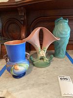Three vases side by side on marble shelf