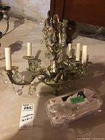 Full view of the five-arm crystal chandelier showing its metal frame, candle-style bulb holders, and hanging crystals.