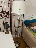 Full view of both lamps showing floor lamp with white shade and table lamp with black shade on furniture.