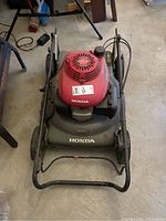 Top view of the Honda gas lawn mower showing red engine cover with Easy Start label and Honda branding on the body.