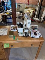 Sewing machine and associated accessories on wooden table in basement environment