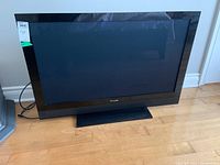 Front view of the Pioneer 41 inch plasma TV showing the black bezel and screen, on its rectangular base stand, placed on a wood floor.