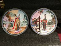 Two collector plates side by side displaying distinct traditional Chinese beauty scenes with floral and architectural elements