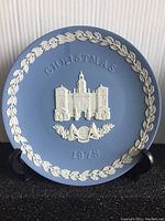 Blue Jasperware plate by Wedgwood depicting Horse Guards with 'Christmas 1978' inscription and white leaf garland border.