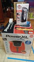 Photo showing boxed Power XL Vortex Air Fryer and Safety Can Express automatic can opener on top