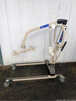 Full front view of beige steel frame lift with U-shaped base and four casters