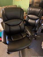 Pair of two black adjustable office chairs side by side.