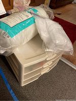 Plastic storage drawers stacked with batting material on top