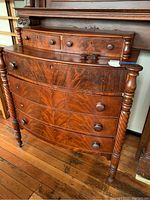 Full view of antique wooden dresser showing front, drawers, and legs.