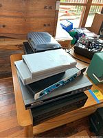 Stack of electronics including a white device with Koch logo, blue audio interface, and various stacked black devices