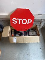 Payphone and STOP sign displayed in the box on concrete floor