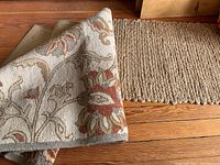 Photo of runner rug with floral pattern showing front and back corners, emphasizing fabric texture and design.