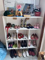 Shoes and boots on white shelving unit including children's and adult sizes in various styles and colors