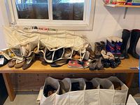 Wide view of shelf showing multiple pairs of ladies shoes, boots and the first cloth shoe organizer filled with shoes