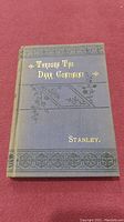 Front cover of the hard cover book 'Through The Dark Continent' showing dark cloth binding with gold embossed title and author name Stanley.