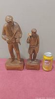 Two wooden figures side by side with a soda can for size reference. Larger is 15x5x4 inches, smaller figure is slightly smaller.
