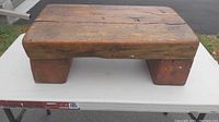Top and side view of antique primitive wooden step stool showing thick top step with cracks and worn surface.