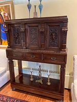 Front view of entire Italian Revival mahogany side buffet showing crown moulding, carved panel doors, drawers, and lower shelf