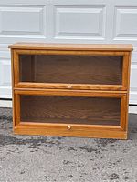 Front view of the two-section barrister bookcase with closed glass-front doors and visible wood grain.