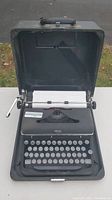 Front angled view of black Royal portable typewriter inside fitted carrying case.