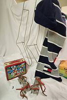 Photo showing Mickey Mouse lunchbox, antique child's metal ice skates, metal wire sock stretchers and navy knit hat hanging