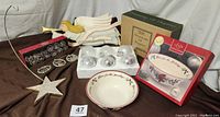 Group photo of all items together including Lenox bowl in box, glass ornaments in original packaging, wooden angels, and metal star ornament stand