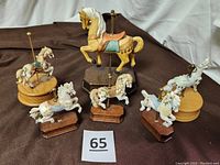 All six carousel horse music boxes arranged together showing size comparisons and wooden bases