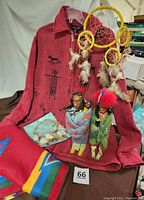 Complete Native American Collection showing red jacket, two dolls in native clothing, large and small dream catchers, fleece throw with motif, and small accessory pouch.