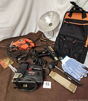 Overview of lot showing Black & Decker Navigator saw, Sears Craftsman scroll saw, mallet, clasp light, foldable tape measure, gloves, tool holder bag, and part of Wagner tool gun.