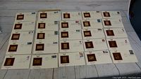 Full display of 25 First Day Covers, each featuring a mounted golden replica US stamp.