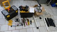 Display of all items in lot showing two tool boxes, hand tools, lighting, plumbing parts and cables