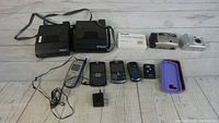 Lot layout featuring all items: 2 Polaroid instant cameras, 4 mobile phones, 2 phone cases, a Rolodex box, film and digital cameras.
