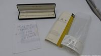 Bracelet in open Kay case alongside handwritten note and packaging