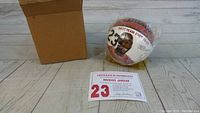 Mini basketball sealed in plastic, showing Michael Jordan portrait, stats, and number 23. Includes certificate of authenticity and cardboard box.