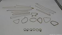 Full lot showing silver necklaces, bracelets, and rings laid out on a white surface.